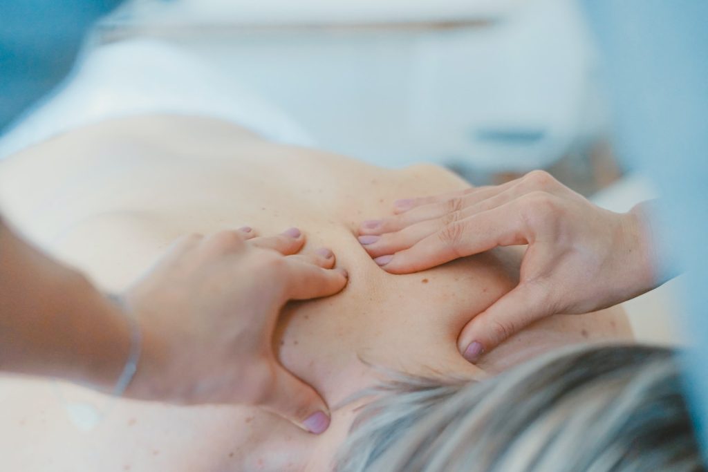 Medecin qui masse le dos d'un patient